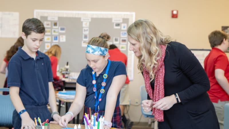 Teacher helping kids in class